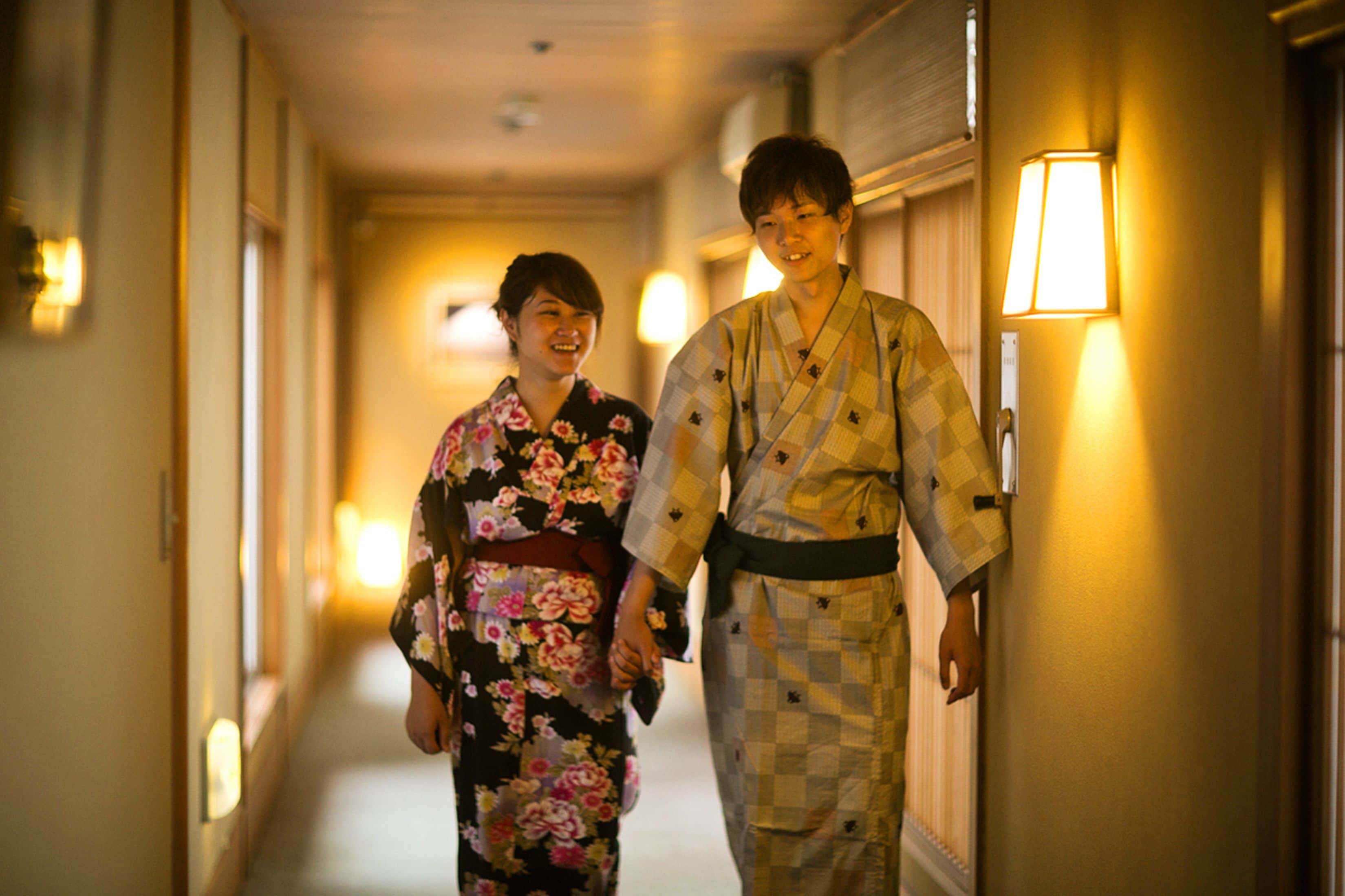 A hallway with two people in traditional attire walking side by side.