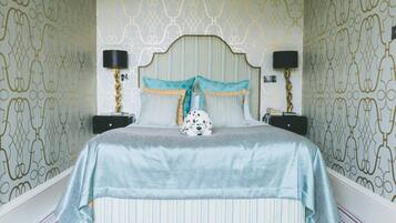 A bedroom with a striped bedspread, a patterned headboard, and two bedside lamps.
