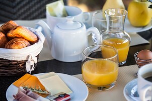 Desayuno con cruasanes, queso, huevos y jugo de naranja.
