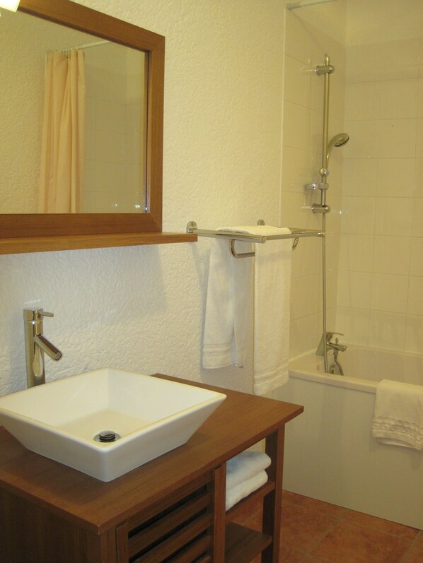 A bathroom with a white sink, a mirror, a shower, and a bathtub. - Le Logis Du Chateau (Vaison-la-Romaine)