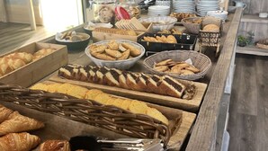 Un buffet proposant une variété de produits de boulangerie et de pâtisserie.