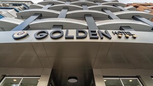 The exterior of the Golden Hotel with a modern architectural design featuring curved lines and a prominent sign. - Hotel Golden (Benidorm)