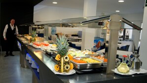 A buffet with various food items and a digital clock displaying 13:13. - Hotel Golden (Benidorm)