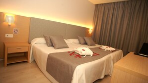A hotel room with a bed, bedside tables, a desk, and a lamp. - Hotel Golden (Benidorm)