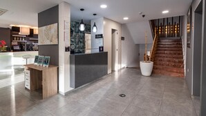 A modern reception area with a reception desk, a staircase, and a reception sign. - Hotel Golden (Benidorm)
