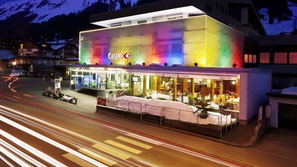 Un edificio moderno con fachada colorida, un letrero de casino y un restaurante con terraza.