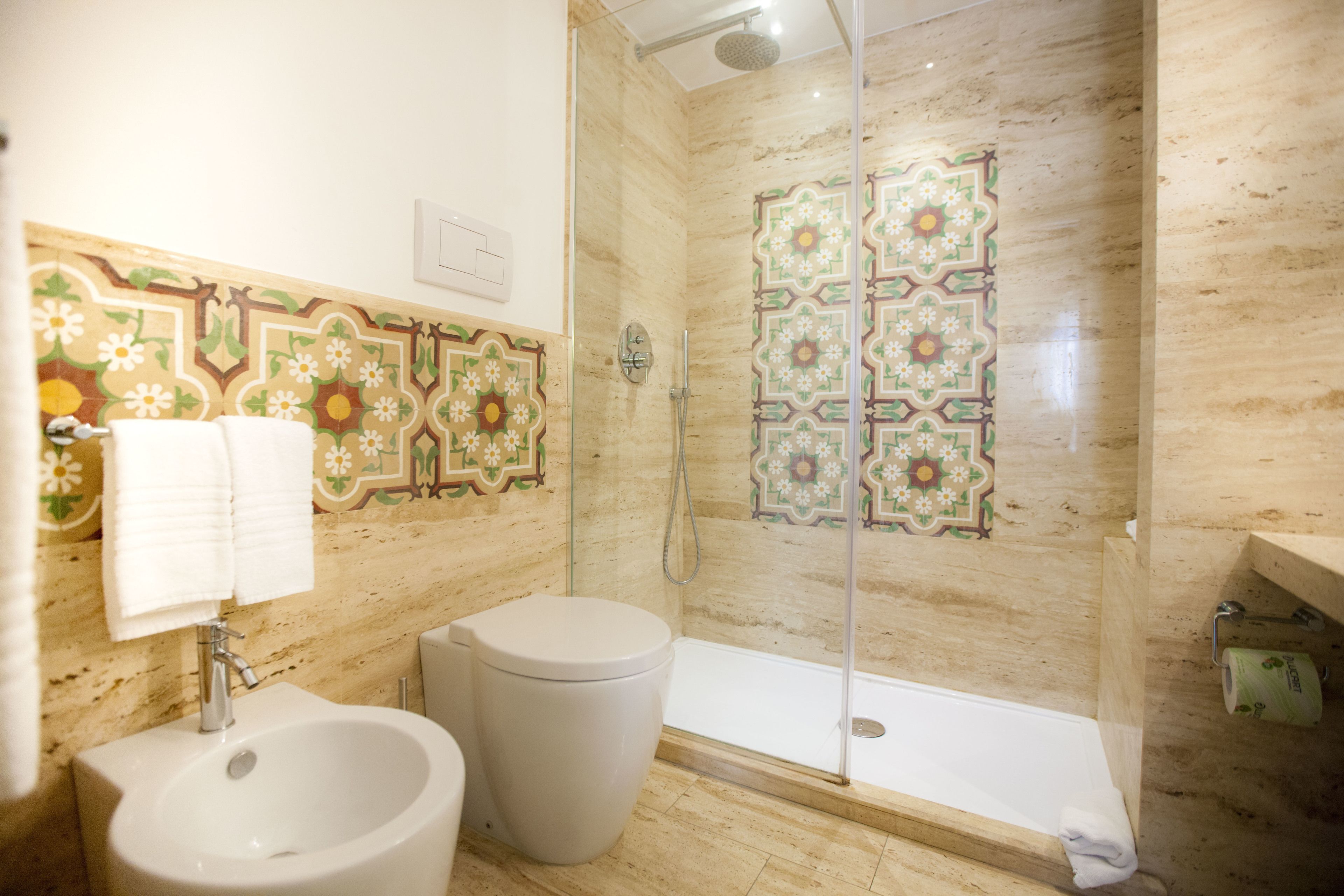 A bathroom with a shower, bidet, and sink.