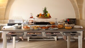 A breakfast buffet setup with various food items and a fruit bowl.