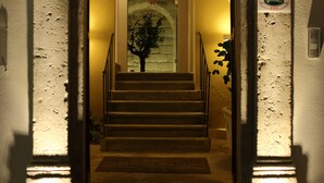 A staircase with a decorative archway, a wall-mounted sign, and a framed picture of a tree.