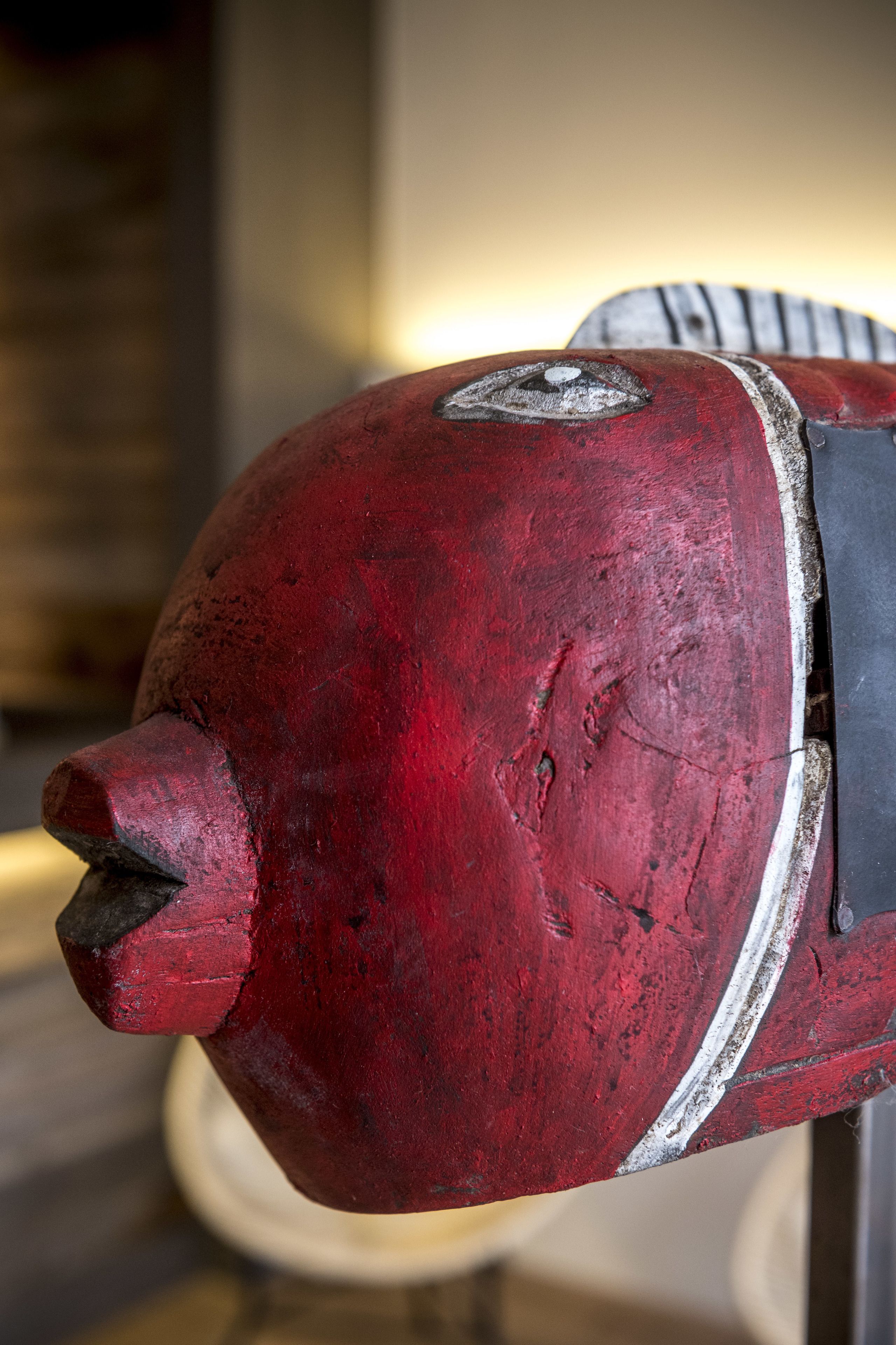 A close-up of a red, weathered object with a pointed end and a circular detail on its side.