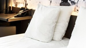 A hotel room with a bed, a nightstand with a lamp, and a wall mural of a boat with the text "EXCURSIONS EN MER". - Hotel Albert Plage (Knokke-Heist)