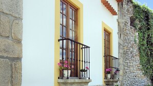 A building with stone walls, yellow windows, and a stone staircase. - Hotel Rural Quinta da Geia (Oliveira do Hospital)