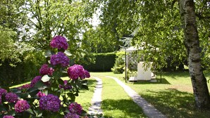Un jardin avec un sentier menant à un belvédère.