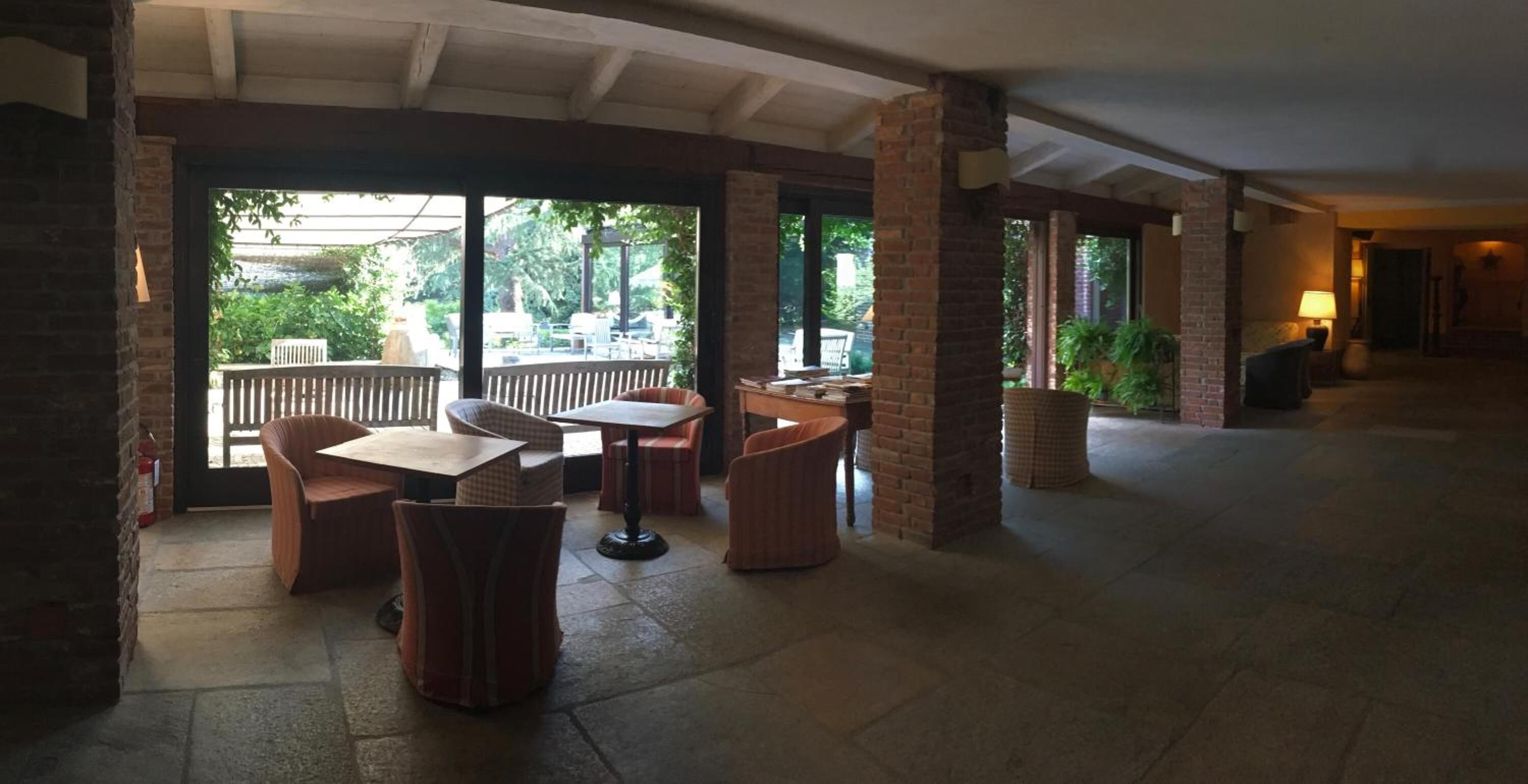 An indoor patio area with brick pillars, tables, and chairs.