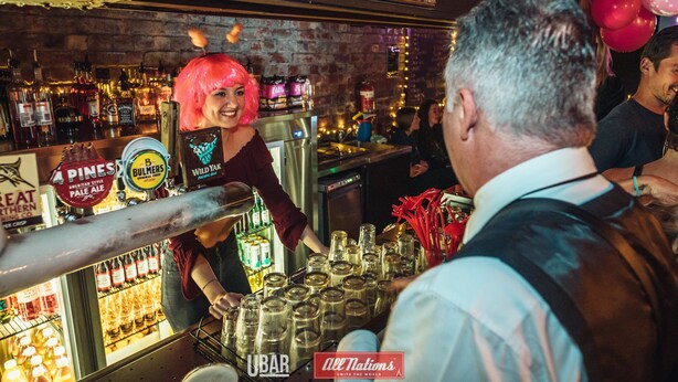 Un bar con una gran variedad de botellas y un cantinero.