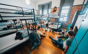 Un dormitorio con literas, suelo de madera y ventanas amplias.
