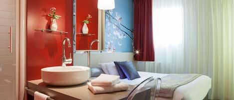 Un baño moderno con un lavabo redondo, un espejo y un perchero para toallas.