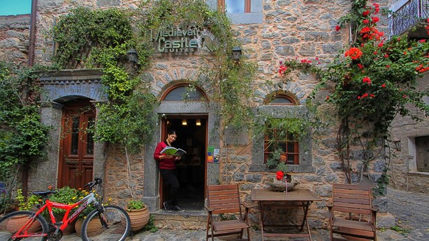 Ein Steinhaus mit einem Schild, auf dem steht: 'Medieval Castle Suites.'