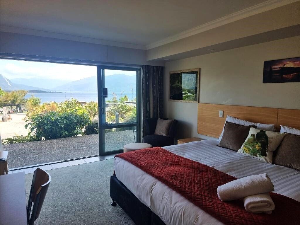 Une chambre d’hôtel avec un grand lit, une vue sur la mer et un balcon.