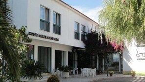Ein Hotel mit weißer Fassade, vielen Fenstern und Außenbereich.