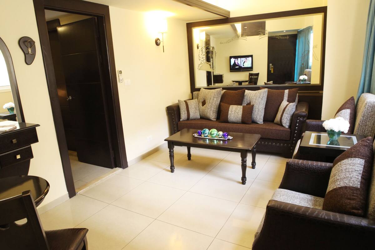 A living room with a sofa, coffee table, and a television.