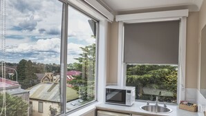 A kitchen with a window, a microwave, and a sink. - Blue Mountains Heritage Motel (Katoomba)