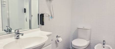 Ein modernes Badezimmer mit einem weißen Waschbecken, einer Toilette und einem Bidet.