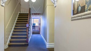 A grand hallway with a staircase leading to reception. - Blue Mountains Heritage Motel (Katoomba)