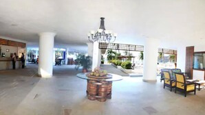 A spacious lobby with a central round table, seating area, and a chandelier. - Hotel Tamacá Beach Resort (Santa Marta)