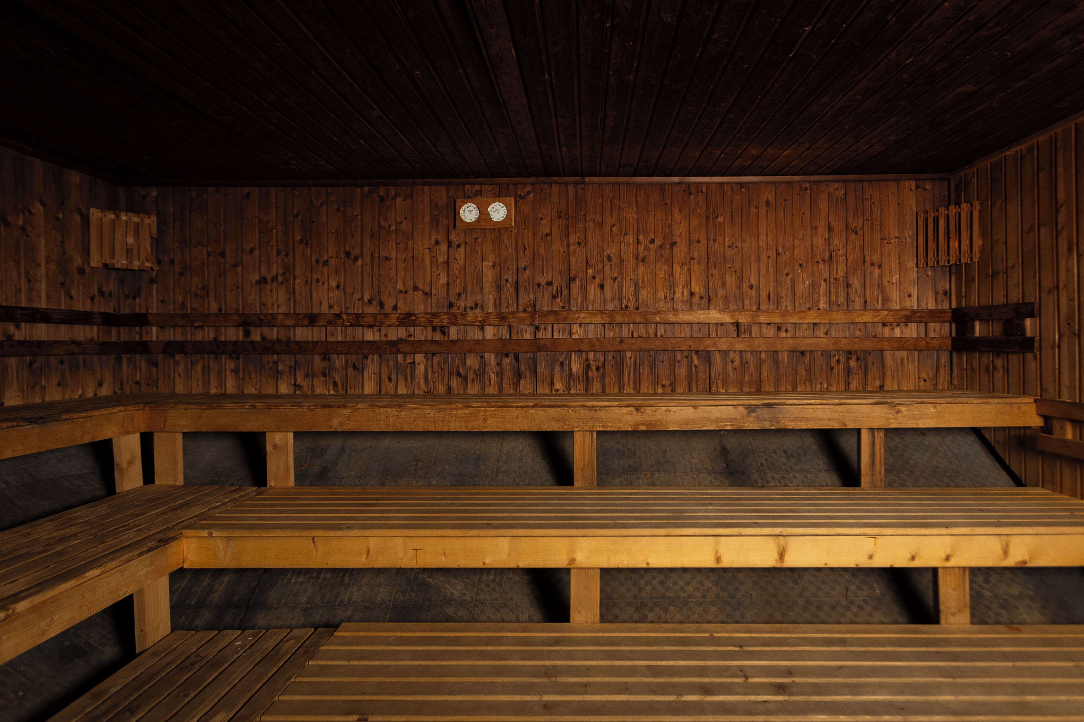 Una sauna de madera con bancos y techo de madera.