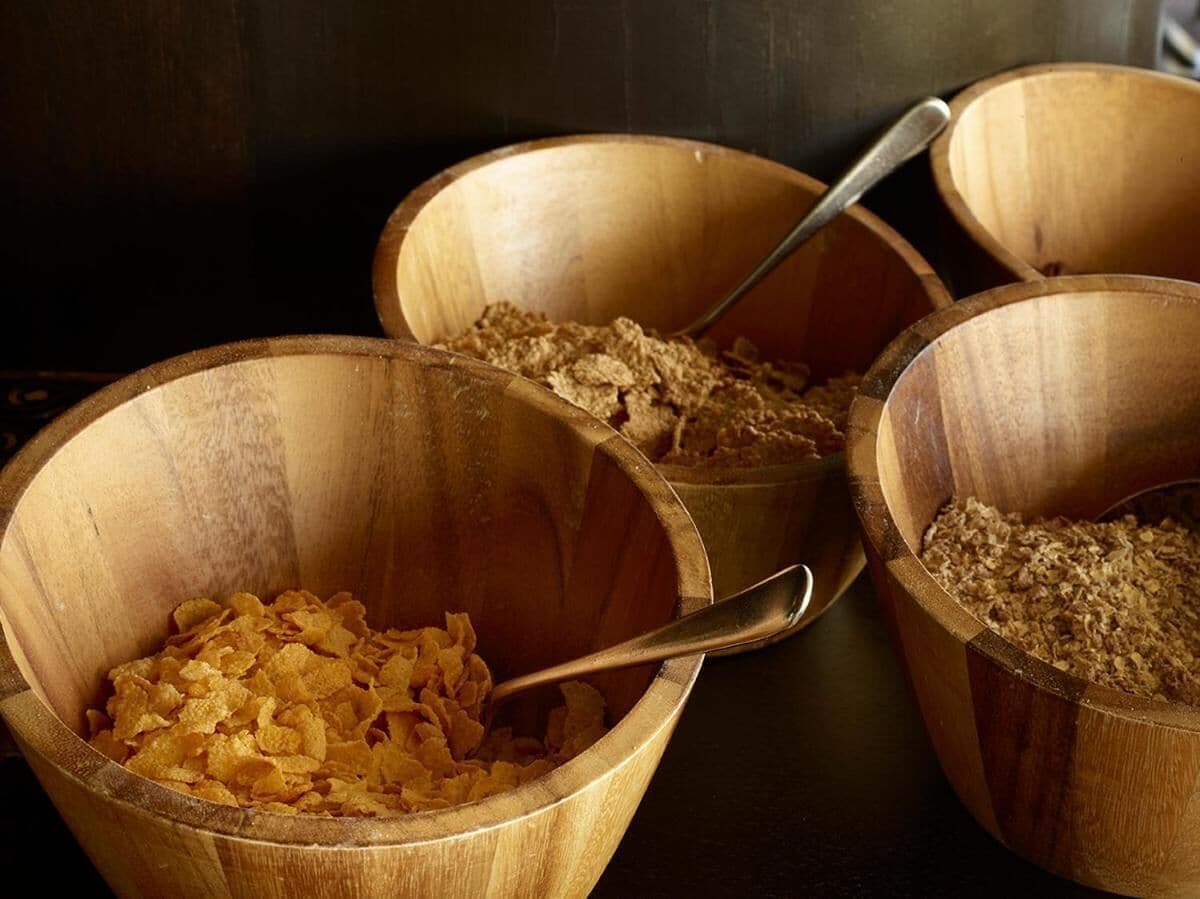 Three wooden bowls containing different food items.