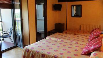 Una habitación de hotel con cama, una silla, un televisor y un espejo.