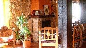 Un interior rústico con paredes de piedra, muebles de madera y una chimenea.