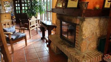 Una sala de estar acogedora con chimenea, muebles de madera y un ventanal grande.