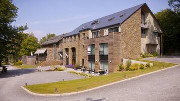 Stunning multi-story building with a sloped roof and balconies, offering a covered entrance and outdoor seating area.