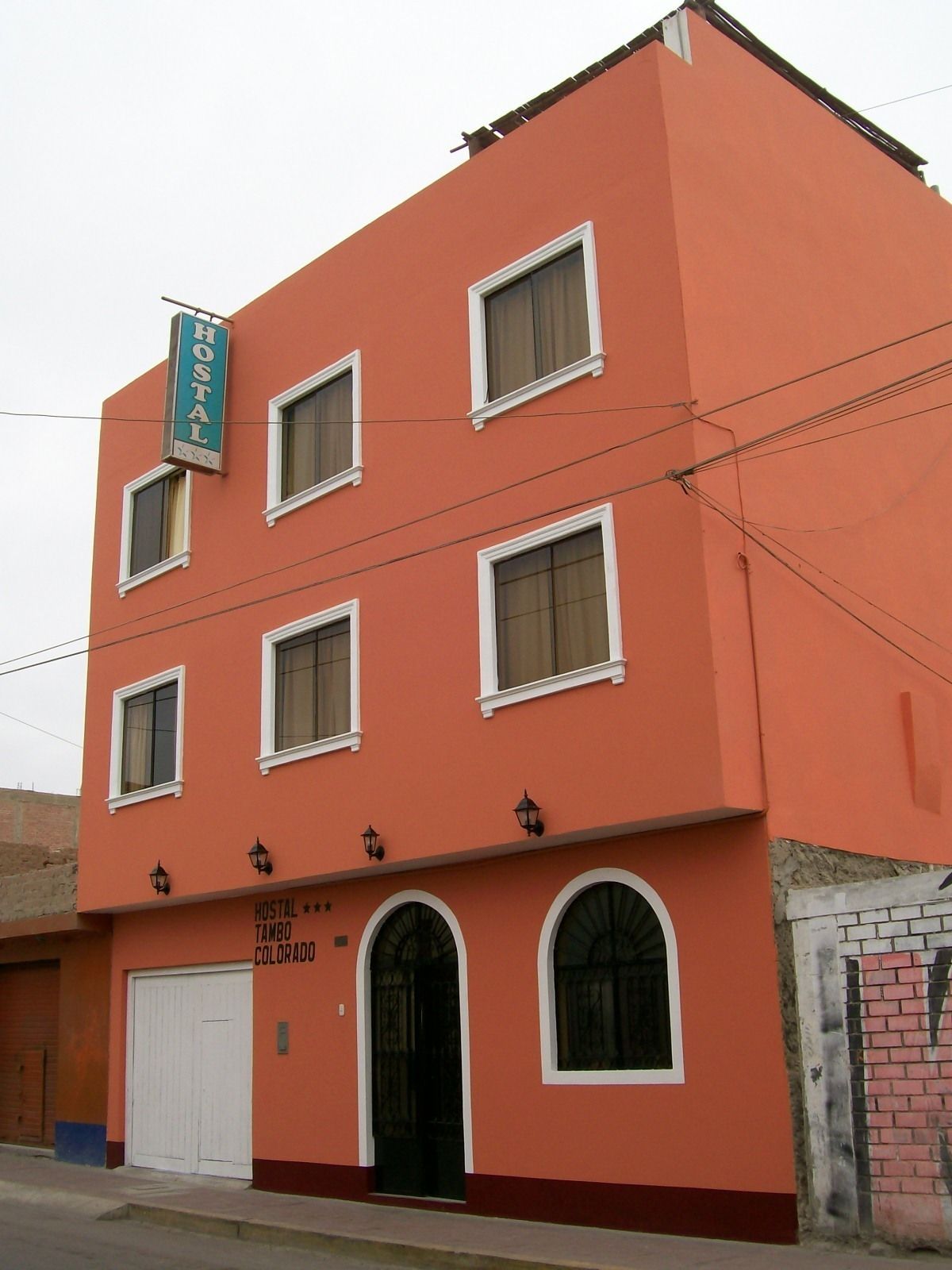 A multi-story building with a sign reading "HOSTAL TAMBO COLORADO".
