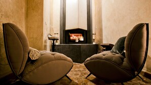 Une pièce chaleureuse avec deux fauteuils en cuir placés face à une cheminée.