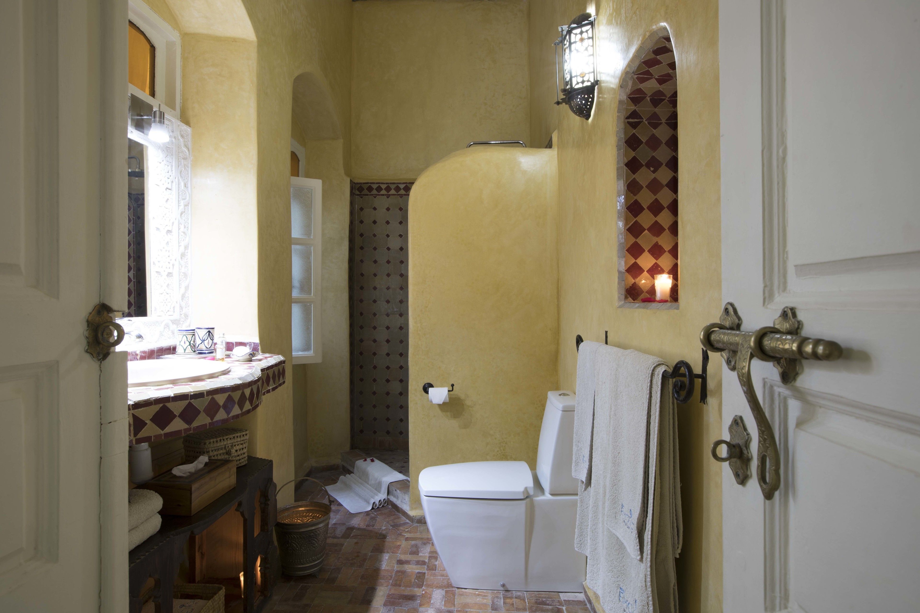 A bathroom with a toilet, sink, and shower area.