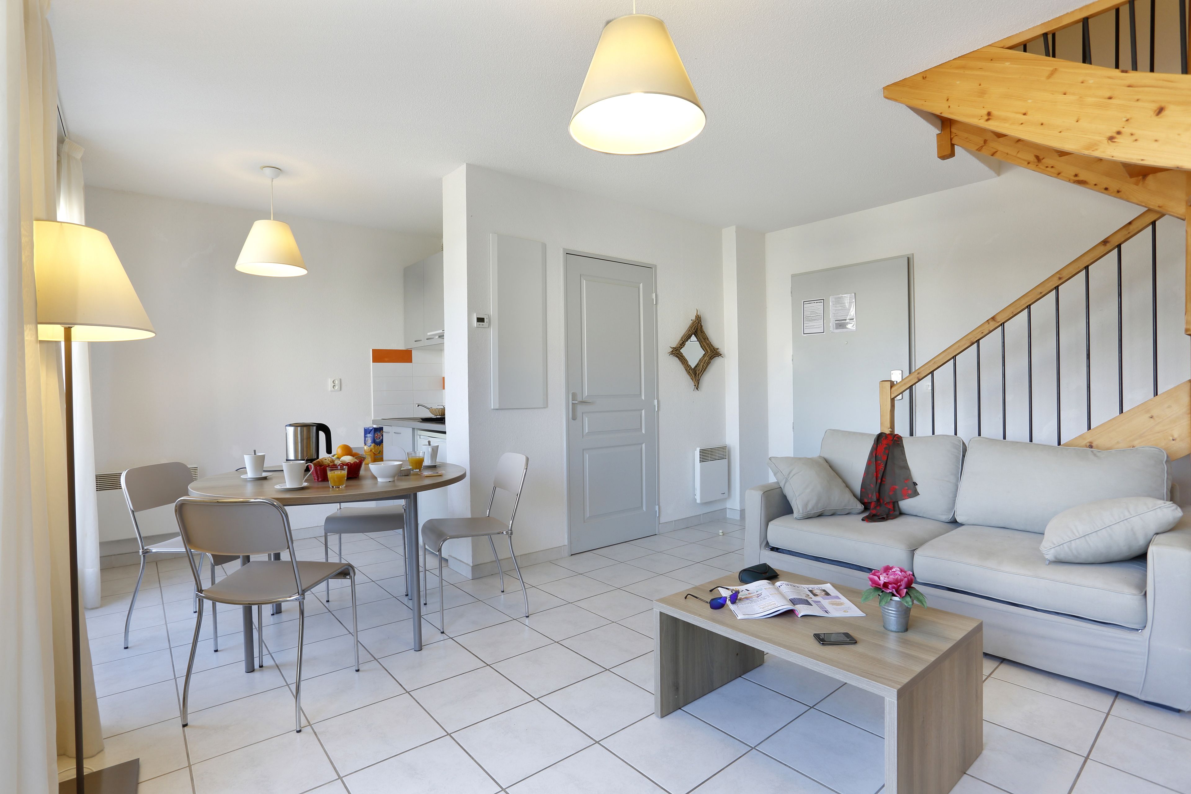 Un salon moderne comprenant un canapé, une table basse et un coin repas avec des chaises et une table.