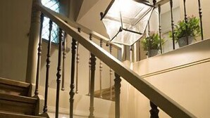 A wooden staircase with a light fixture hanging from the ceiling.