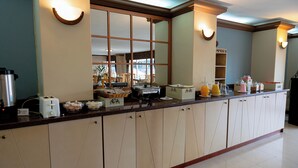 Una cocina con una encimera amplia, equipada con un tostador, cafetera y diversos electrodomésticos.