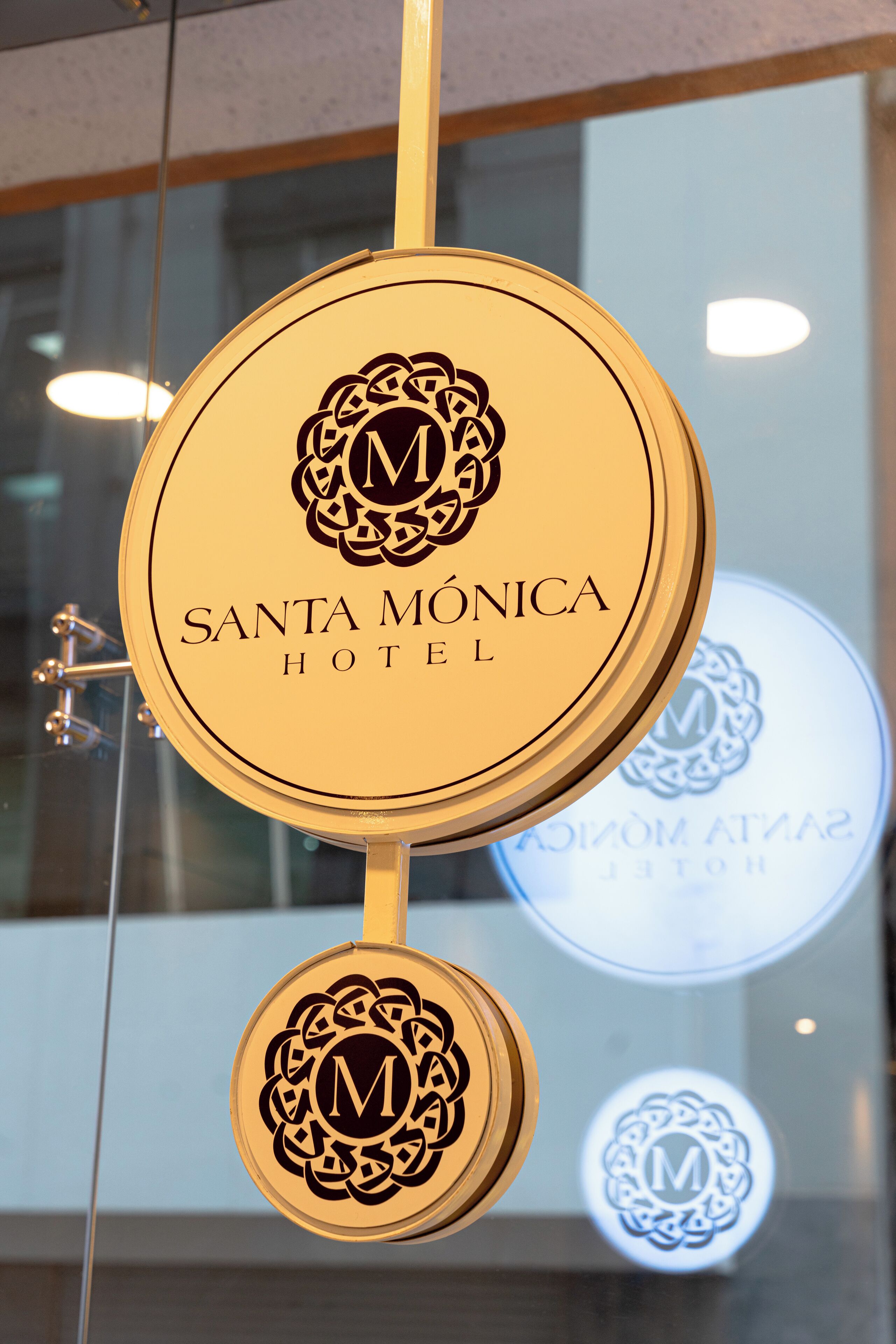 A hotel sign with the name "Santa Mónica Hotel" and a logo.