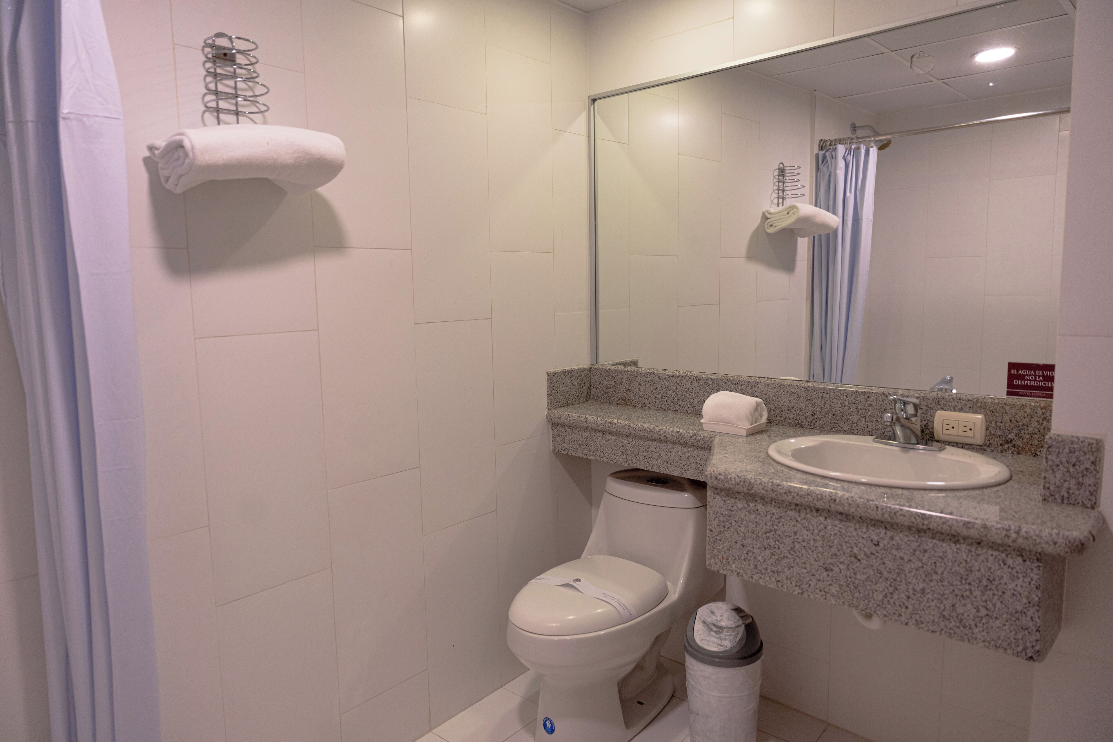 Ein Badezimmer mit Toilette, Waschbecken und Spiegel.