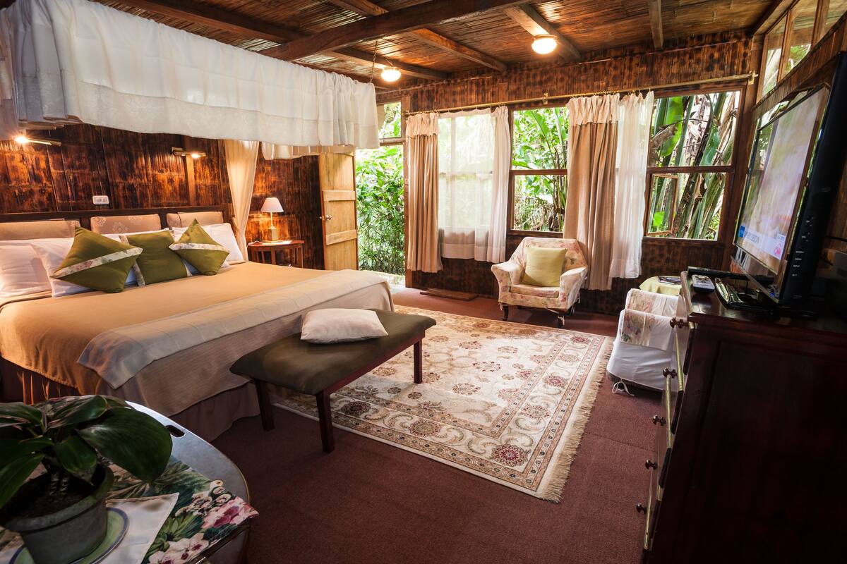 Ein gemütliches Schlafzimmer mit einem großen Bett, einer Bank, einem Schreibtisch und einem Sessel.