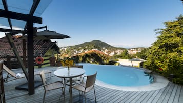 Una piscina al aire libre, sillones reclinables de piscina