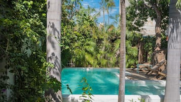 Una piscina al aire libre, sillones reclinables de piscina