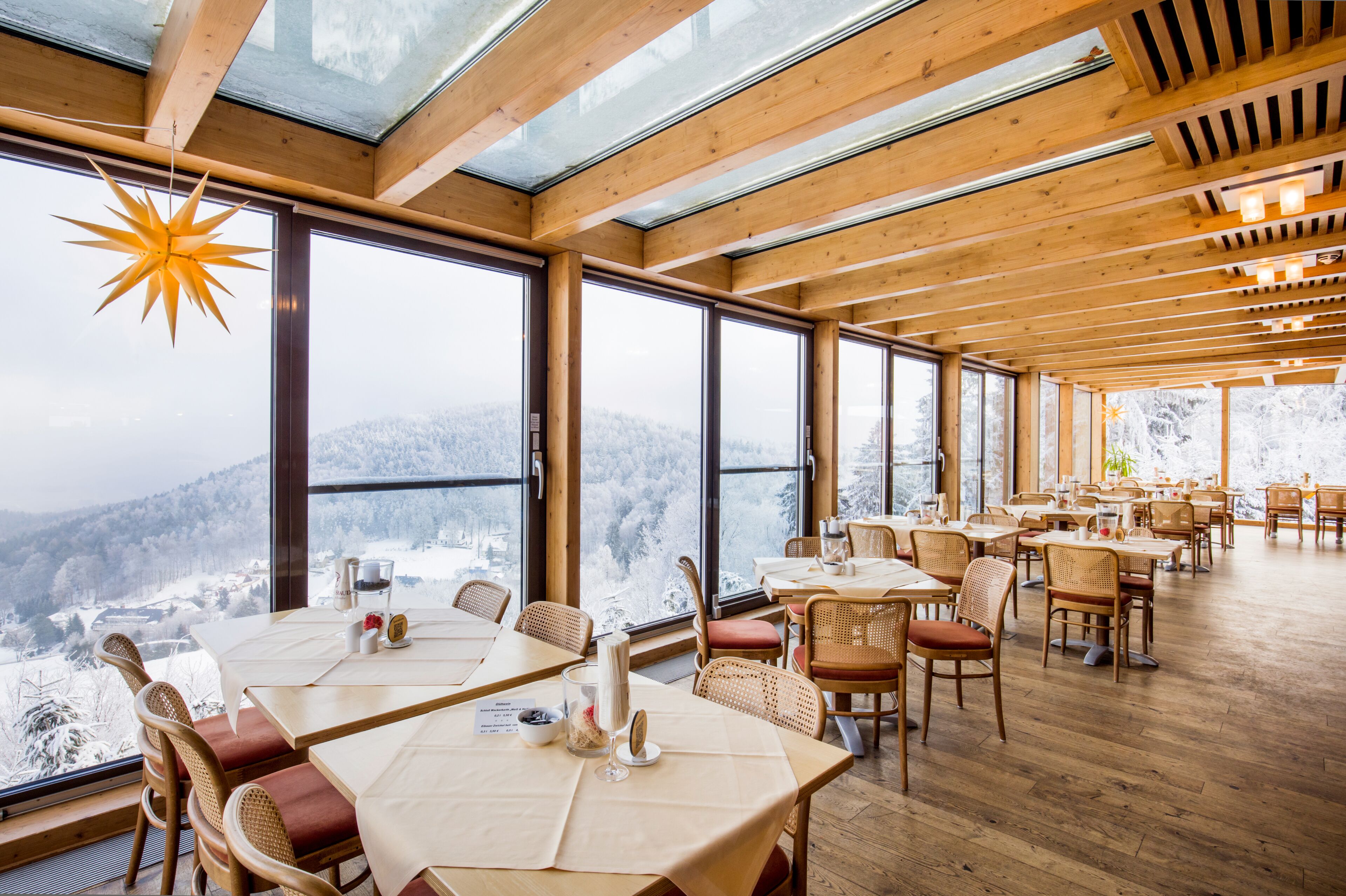 Un restaurant amb grans finestres que ofereix vistes a muntanyes cobertes de neu.