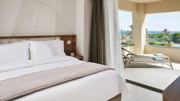 A hotel room with a bed, a nightstand, a lamp, and a view of a balcony with a pool and palm trees.