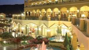 Un hôtel à plusieurs étages doté d’une cour intérieure agrémentée d’une fontaine et de jardins aménagés.