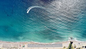 An aerial view of a coastal resort with a beach, swimming pools, and a marina. - Lindos Princess Beach Hotel All Inclusive (Rhodes)